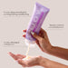 Hand holding a purple 'ENJOY' hair care product with text about its benefits on a light gray background