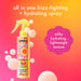 Amika frizz-me-not spray bottle with colorful label on a gradient background