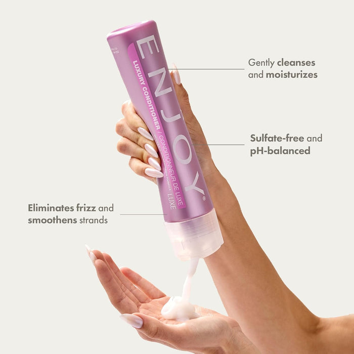 Hand holding 'ENJOY Luxury Conditioner' bottle with product application on a white background