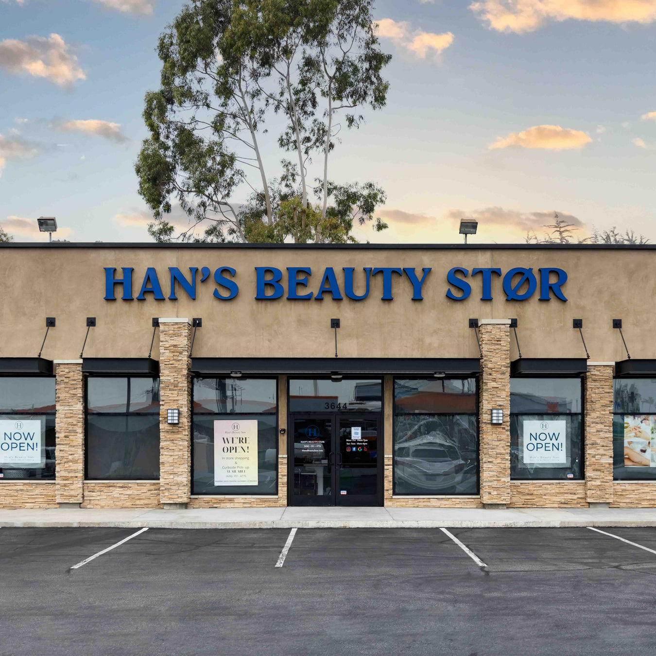 Image of the front of Han's Beauty Stør's location in Pasadena on the corner of foothill and rosemead. It also shows the ample parking spaces and a beautiful backdrop of a sunset